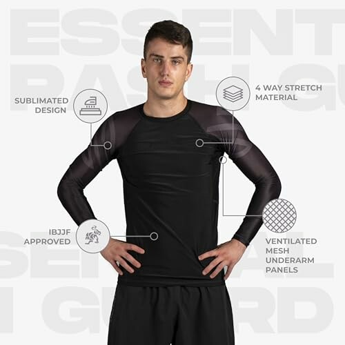 A man wearing a black rashguard with design features highlighted, demonstrating its features and benefits.