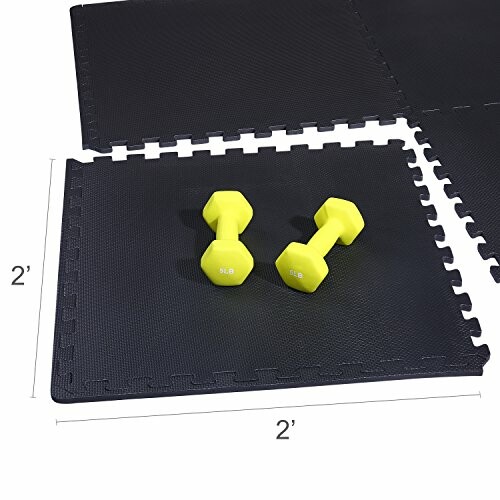 Yellow dumbbells on interlocking black exercise mats.